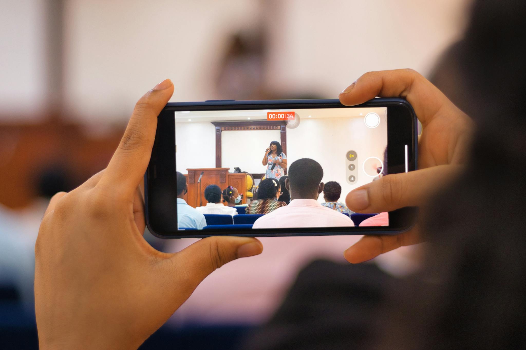 Audience recording a live performance with a smartphone, showcasing modern technology use.